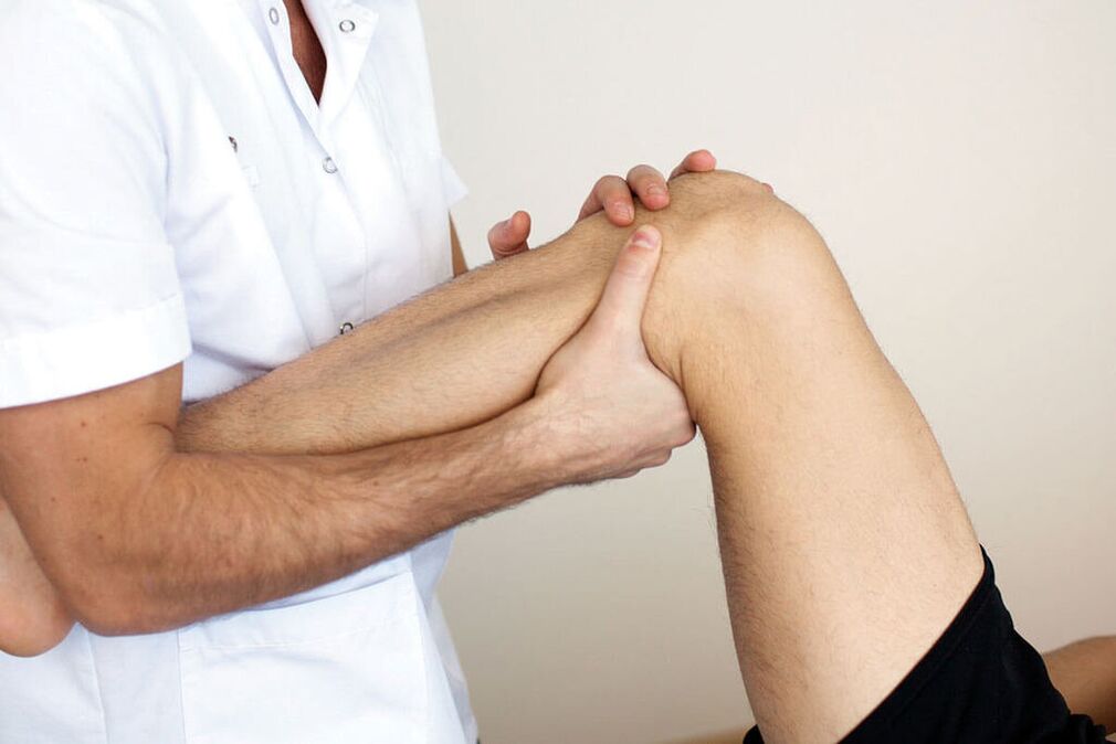 lékař zkoumá koleno s artrózou